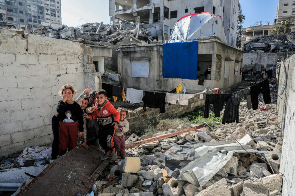 A group of people standing next to a pile of rubble
